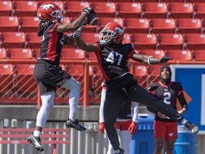 Calgary Stampeders Nick Taylor (left) and Brad Muhammad go for the ball during team practice at McMahon Stadium.