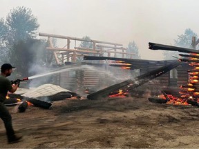 Residents battle flames at the North American Log Crafters in Scotch Creek in the Shuswap region. Credit: Mark Acton