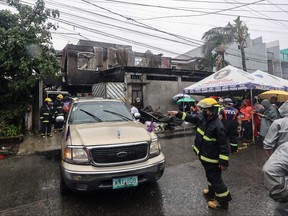 Firemen direct a vehicle after a fire at a house in Quezon City, suburban Manila on August 31, 2023.