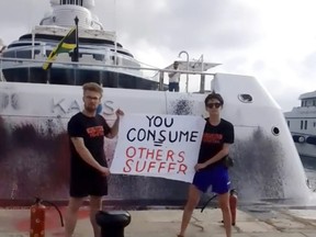 In this frame from video provided by Karen Killeen, protesters demonstrate in front of a super yacht belonging to Walmart heir Nancy Walton Laurie after spray paining it in Ibiza, Spain on July 16, 2023. Climate activists have spraypainted a superyacht, blocked private jets from taking off and plugged holes in golf courses this summer as part of an intensifying campaign against the emissions-spewing lifestyles of the ultrawealthy.