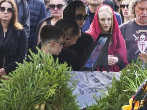 People react by the coffin of the Wagner Group's logistics chief Valery Chekalov, killed in the plane crash, during a funeral at the Severnoye cemetery in St. Petersburg, Russia, Tuesday, Aug. 29, 2023. The plane crash came exactly two months after Wagner Group's chief Yevgeny Prigozhin launched a rebellion against the Russian military leadership, leading his mercenaries to take over the military headquarters in the southern city of Rostov-on-Don and then launching a march on Moscow.