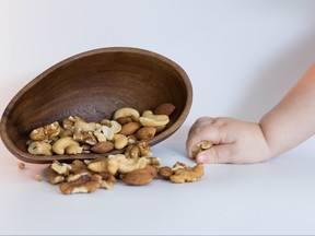 A baby grabs nuts in a photo illustration