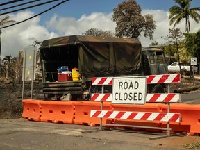 A road is closed, preventing access to a burned neighbourhood in the aftermath of a wildfire, in Lahaina, Maui, Hawaii on August 14, 2023.