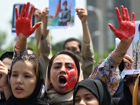 Afghan nationals carry placards and shout slogans during a demonstration against the Taliban government in Islamabad on August 15, 2023.