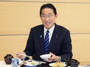 This handout photo taken and received from the Cabinet Public Relations Office via Jiji Press on August 30, 2023 shows Japan's Prime Minister Fumio Kishida posing as he eats seafood from Fukushima prefecture at the prime minister's office in Tokyo.
