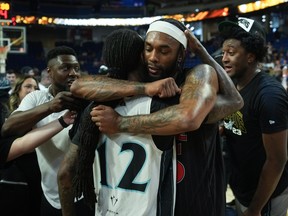 Calgary Surge's Terry Henderson Jr., back centre, and Scarborough Shooting Stars' Cat Barber embrace after Scarborough defeated Calgary in the CEBL basketball championship final, in Langley, B.C