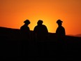 CalFire crewmen walk through the charred grass of the Almond Fire which burned over 5,200 in Lost Hills, California, August 6, 2023.