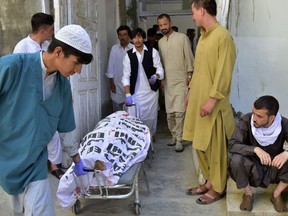 Hospital staff and relatives transport the body of a police officer at a hospital, in Quetta, Pakistan Tuesday, Aug. 1, 2023.