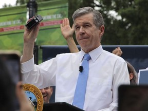 North Carolina Democratic Gov. Roy Cooper affixes his veto stamp to a bill banning nearly all abortions after 12 weeks of pregnancy at a public rally, May 13, 2023, in Raleigh, N.C.