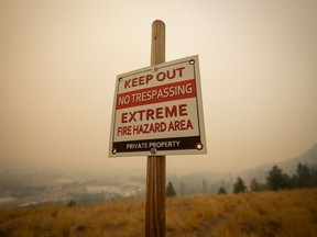 A warning sign about fire risk is seen as smoke from wildfires fills the air in Kelowna, B.C., on Saturday, Aug. 19, 2023.