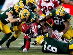 The Calgary Stampeders' Ka'Deem Carey (35) is tackled by the Edmonton Elks during second half CFL action at Commonwealth Stadium