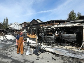 Fire investigator Mike Noblett investigates at the scene of a large fire that affected many homes and destroyed garages in the McKenzie Towne neighbourhood in southeast Calgary early on Monday, Sept. 11.