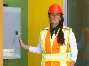 Sarah Hughes, director of development and communications for Children's Cottage Society, poses at the Hope's Cradle door at the construction site in northwest Calgary on Friday.
