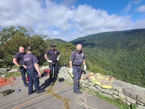 Reems Creek firefighters are pictured at the scene after a woman fell down a cliff at Glassmine Falls Overlook in North Carolina on Saturday.