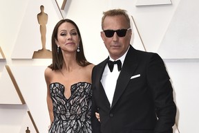 Christine Baumgartner and Kevin Costner arrive at the Oscars, March 27, 2022, at the Dolby Theatre in Los Angeles.