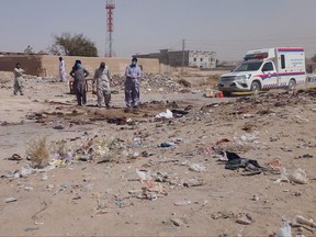 Security officials examine the site of a suicide bomb attack targeting a procession marking the birthday of Islam's Prophet Mohammed in Mastung district on Sept. 29, 2023.