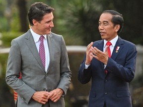 Indonesia President Joko Widodo (right) speaks with Prime Minister Justin Trudeau as they walk before holding a bilateral meeting at the presidential palace in Jakarta on September 5, 2023.