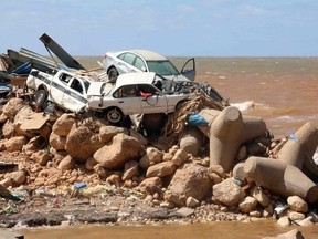Cars are piled up atop wave breakers and the rubble of a building destroyed in flash floods after the Mediterranean storm "Daniel" hit Libya's eastern city of Derna, on September 14, 2023. A global aid effort for Libya gathered pace on September 14 after a tsunami-sized flash flood killed at least 4,000 people, with thousands more missing, a death toll the UN blamed in part on the legacy of years of war and chaos.