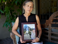 Deborah Blum holds a photo of her child, Esther Iris, who died by suicide in 2021. When it came time to write the death notice, Blum was open and specific about the mental health struggles that led to her child’s death. (Lauren Justice/KFF Health News)