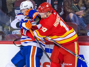 Calgary Flames forward Jonathan Huberdeau and Edmonton Oilers defenceman Brett Kulak collide during preseason NHL action at the Scotiabank Saddledome in Calgary on Friday