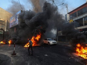 Palestinians burn tires and waste during an Israeli military operation in the Jenin refugee camp in the occupied West Bank on July 3, 2023.