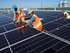 Workers for the City of Edmonton were installing Canada's largest rooftop solar panel array at the Edmonton Expo Centre on August 18, 2022.
