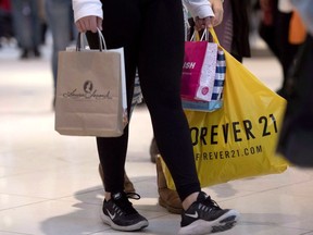 A shopper carries purchases at Ottawa's Rideau Centre mall on Wednesday, Dec. 26, 2018.