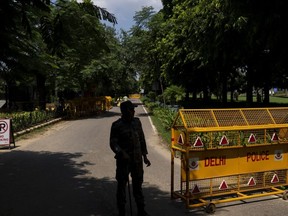 An Indian paramilitary soldier stands guard next to a police barricade outside the Canadian High Commission in New Delhi, India, Tuesday, Sept. 19, 2023.