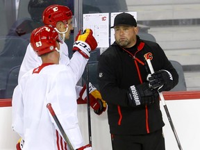 Calgary Flames assistant coach Marc Savard talks with players during practice.