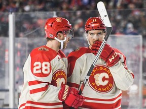 Mikael Backlund (right) and Elias Lindholm of the Calgary Flames confer during a break in play against the Edmonton Oilers.