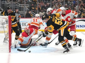 Jacob Markstrom #25 of the Calgary Flames tends net as Jake Guentzel #59 of the Pittsburgh Penguins shoots the puck during the first period at PPG PAINTS Arena