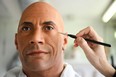 A painter works on updating a wax figure of Dwayne Johnson at the Grévin Museum in Paris.