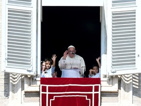 Pope Francis waves to the pilgrims flanked by children from the five continents during the Sunday Angelus prayer in St.Peter's Square at the Vatican on October 1, 2023.