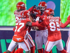 Calgary Stampeders congratulate linebacker Cameron Judge after he ran in a touchdown against the Saskatchewan Roughriders at McMahon Stadium in Calgary on Friday