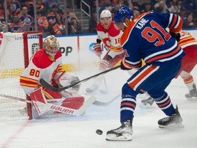 Evander Kane (91) of the Edmonton Oilers, can’t handle a bouncing puck in front of goalie Dan Vladar of the Calgary Flames at Rogers Place in Edmonton on Oct. 4, 2023.