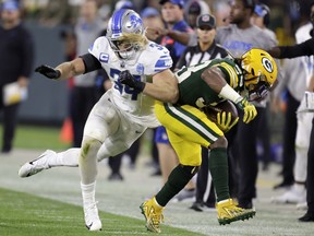 Green Bay Packers running back Aaron Jones (33) is pushed out of bounds by Detroit Lions linebacker Alex Anzalone (34) during the second half of an NFL football game, Thursday, Sept. 28, 2023, in Green Bay, Wis.
