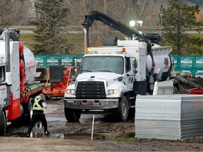 Crews work on a main sewer line break causing an overland sewage discharge into the Bow River at the intersection of Griffin Road and Highway 22 in Cochrane on Sunday, October 22, 2023.