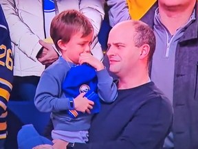 A father and son react during the Canadian National Anthem at the Buffalo Sabres-Boston Bruins game on Tuesday.
