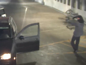 Screen capture from a parkade security camera in Red Deer shows someone with a compound bow aimed at police on May 24, 2021.