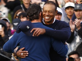 Rory McIlroy and Tiger Woods embrace after finishing their round on the 18th green during the first round of The Genesis Invitational.