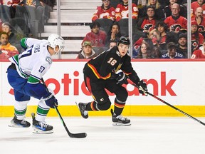 Nikita Zadorov #16 of the Calgary Flames skates with the puck against Tyler Myers #57 of the Vancouver Canucks during the third period of an NHL game at Scotiabank Saddledome on November 16, 2023 in Calgary, Alberta, Canada
