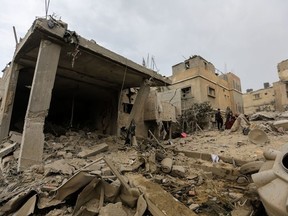 People search through buildings, destroyed during Israeli air strikes in the southern Gaza Strip on November 12, 2023 in Khan Yunis, Gaza.