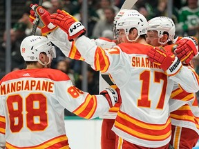 Yegor Sharangovich #17 of the Calgary Flames celebrates with teammates after scoring a goal during the second period against the Dallas Stars at American Airlines Center