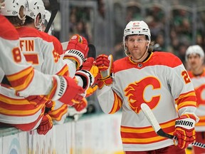 Blake Coleman #20 of the Calgary Flames is congratulated by his bench after scoring a goal during the third period against the Dallas Stars at American Airlines Center