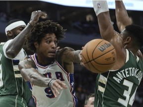 Philadelphia 76ers' Kelly Oubre Jr. asses between Milwaukee Bucks' Giannis Antetokounmpo and Bobby Portis during the first half of an NBA basketball game Thursday, Oct. 26, 2023, in Milwaukee.