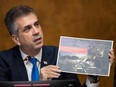 Israel Foreign Minister Eli Cohen shows an image of an Israeli soldier posing next to a weapons cache, which was allegedly found at the Rantisi Hospital in Gaza according to the Israeli army, as he speaks in a press conference at the European Office of the United Nations, Palais des Nation, in Geneva, Tuesday, Nov. 14, 2023.