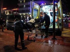 Medical personnel carry on a stretcher a body from the Comoros-flagged cargo ship that has sunk off the island of Lesbos, on November 26, 2023. Greek rescuers on November 26, 2023, were searching for 12 people missing after a ship sank in gale-force winds off the Aegean island of Lesbos, with the authorities finding one crew member dead and saving another.