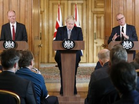 Britain's prime Minister Boris Johnson, centre, Chief Medical Officer for England Chris Whitty, left, and Chief Scientific Adviser Patrick Vallance speak hold a press conference at Downing Street on the government's coronavirus action plan in London, Tuesday, March 3, 2020.