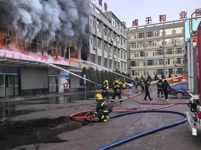 In this photo released by Xinhua News Agency, firefighters try to put out a fire at a building of the the Yongju Coal Company in Lyuliang city in northern China's Shanxi province, on Thursday, Nov. 16, 2023. A fire in the coal company building in a northern Chinese city has killed dozens of people and injured others.