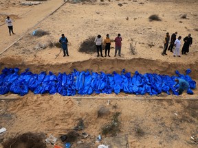 Palestinians bury bodies in a mass grave in Khan Yunis cemetery, in the southern Gaza Strip on November 22, 2023.
